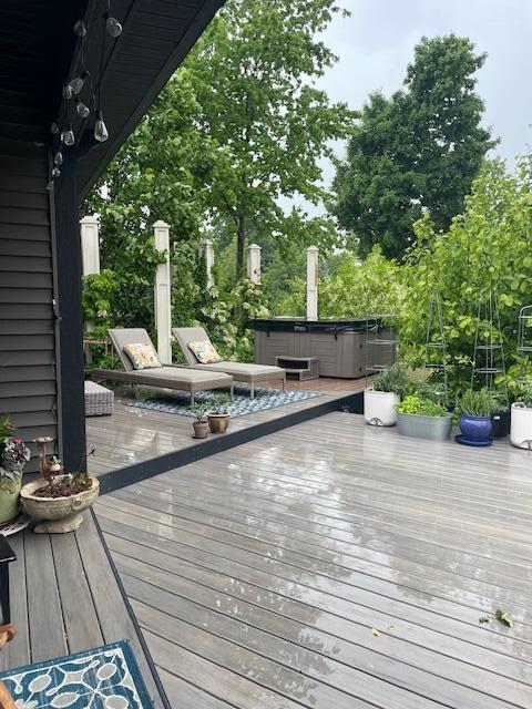 wooden terrace featuring a hot tub