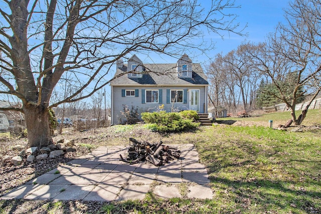 rear view of house with a yard and an outdoor fire pit