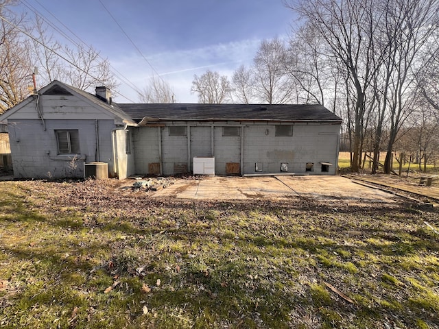 back of property featuring cooling unit and a chimney