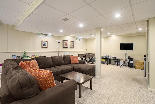 carpeted living area featuring a drop ceiling, recessed lighting, and visible vents