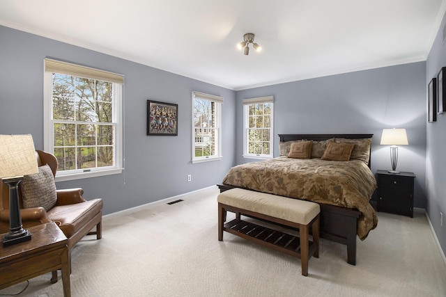 bedroom featuring baseboards, visible vents, ornamental molding, and light carpet