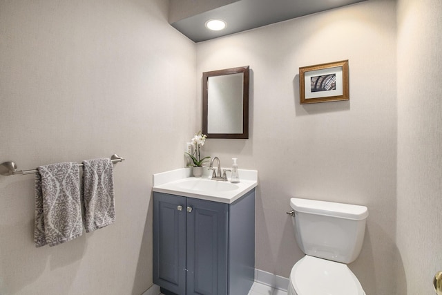 bathroom with vanity, baseboards, and toilet
