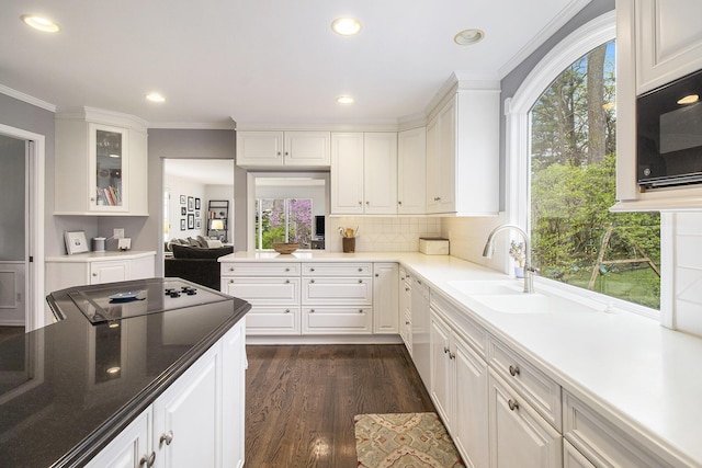 kitchen featuring crown molding, dark wood-style flooring, recessed lighting, white cabinetry, and a sink
