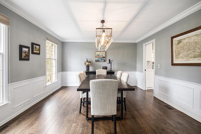 dining space with an inviting chandelier, ornamental molding, and dark wood-style floors