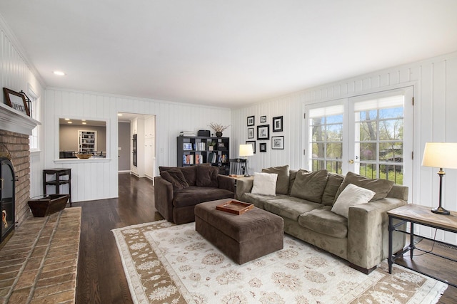 living room featuring crown molding, wood finished floors, and a fireplace