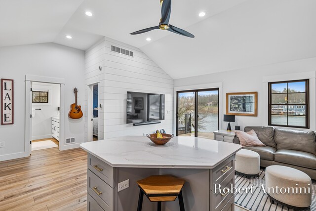 2301 Schimperle Dr NE, Grand Rapids, MI 49525 - kitchen featuring gray cabinets, vaulted ceiling, light wood-style flooring, open floor plan, and a center island