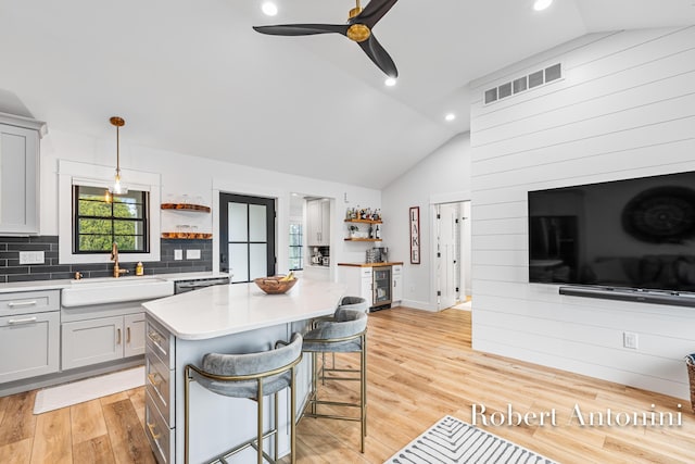 2301 Schimperle Dr NE, Grand Rapids, MI 49525 - kitchen with a sink, open shelves, lofted ceiling, wine cooler, and light countertops