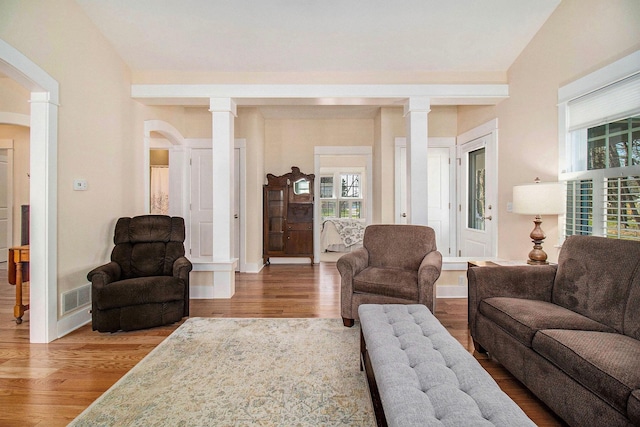 8 Georgia Ct, Pentwater, MI 49449 - living room featuring arched walkways, baseboards, decorative columns, wood finished floors, and visible vents
