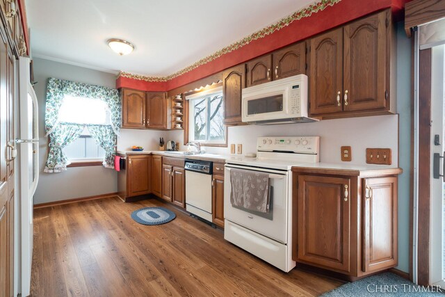 15230 Van Buren St Unit B, Holland, MI 49424 - kitchen featuring brown cabinets, light countertops, wood finished floors, a sink, and white appliances