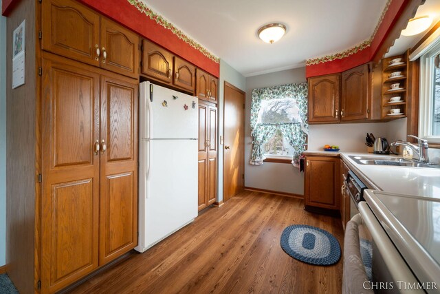 15230 Van Buren St Unit B, Holland, MI 49424 - kitchen with light wood finished floors, freestanding refrigerator, a sink, and brown cabinets