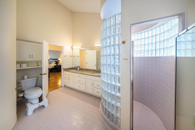 2925 Exmoor Rd, Ann Arbor, MI 48104 - bathroom with a high ceiling, toilet, double vanity, a shower, and tile patterned flooring