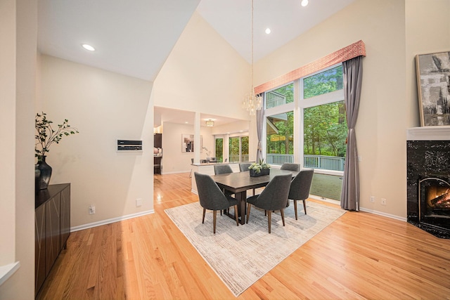 2925 Exmoor Rd, Ann Arbor, MI 48104 - dining space featuring light wood finished floors, a chandelier, a high end fireplace, recessed lighting, and baseboards