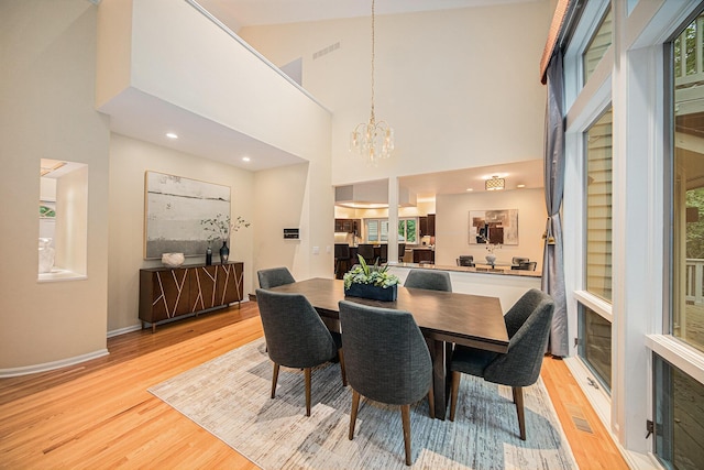 2925 Exmoor Rd, Ann Arbor, MI 48104 - dining area featuring light wood-style flooring, a chandelier, a towering ceiling, baseboards, and recessed lighting