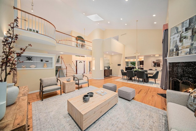 2925 Exmoor Rd, Ann Arbor, MI 48104 - living room with wood finished floors, stairs, a fireplace, high vaulted ceiling, and recessed lighting