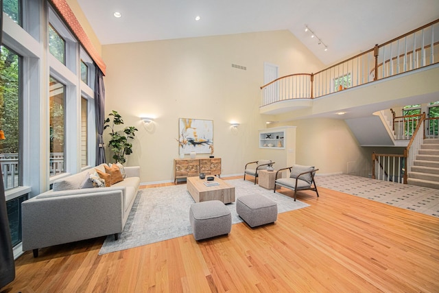 2925 Exmoor Rd, Ann Arbor, MI 48104 - living area featuring stairway, high vaulted ceiling, wood finished floors, and baseboards