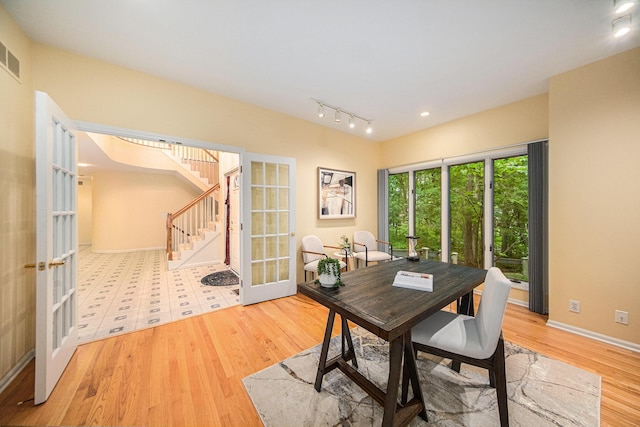 2925 Exmoor Rd, Ann Arbor, MI 48104 - dining area with french doors, wood finished floors, stairway, baseboards, and track lighting