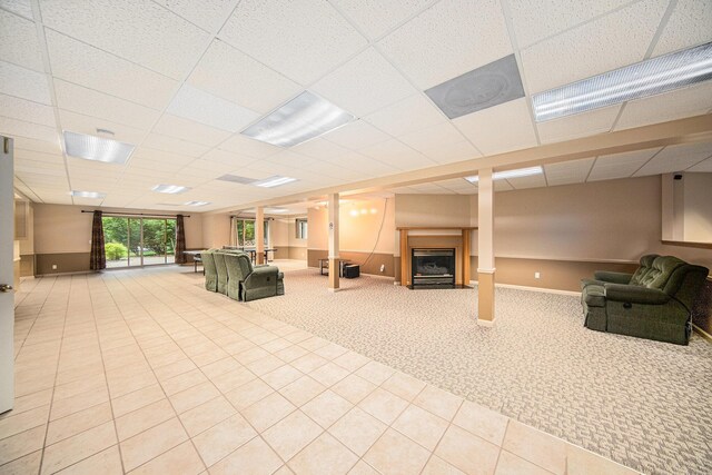 2925 Exmoor Rd, Ann Arbor, MI 48104 - unfurnished living room with a fireplace, carpet floors, a paneled ceiling, baseboards, and tile patterned flooring