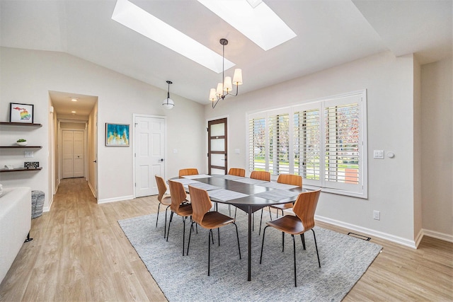 55 Gabriel Dr, South Haven, MI 49090 - dining room featuring a skylight, vaulted ceiling, light wood-type flooring, a chandelier, and baseboards