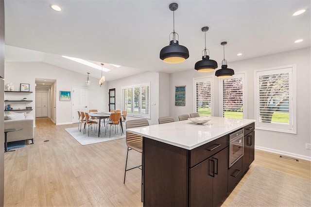 55 Gabriel Dr, South Haven, MI 49090 - kitchen featuring a breakfast bar area, dark brown cabinets, baseboards, light countertops, and recessed lighting