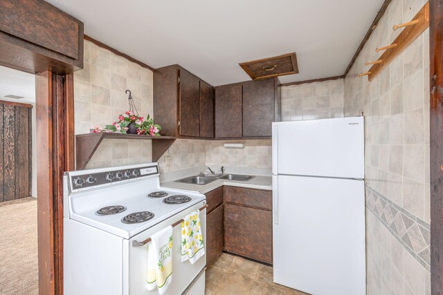 430 N Perry St, Barryton, MI 49305 - kitchen with dark brown cabinets, a sink, white appliances, and tile walls