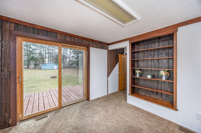 430 N Perry St, Barryton, MI 49305 - unfurnished room featuring carpet floors, a textured ceiling, wood walls, and visible vents