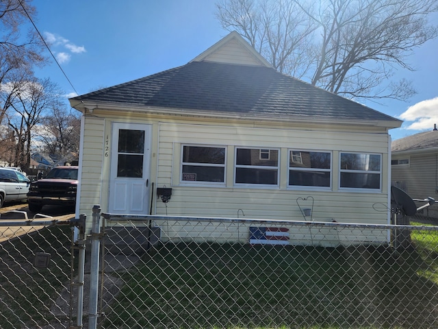 view of home's exterior with fence and a shingled roof