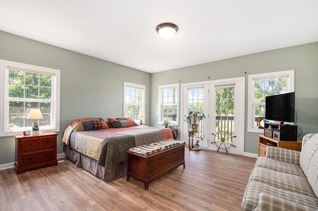 672 66th St, South Haven, MI 49090 - bedroom featuring access to exterior, light wood-type flooring, and multiple windows