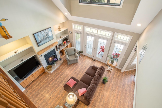 672 66th St, South Haven, MI 49090 - living room featuring a high ceiling, plenty of natural light, recessed lighting, a warm lit fireplace, and wood finished floors