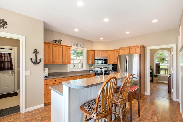 672 66th St, South Haven, MI 49090 - kitchen featuring appliances with stainless steel finishes, healthy amount of natural light, a kitchen island, recessed lighting, and a kitchen breakfast bar