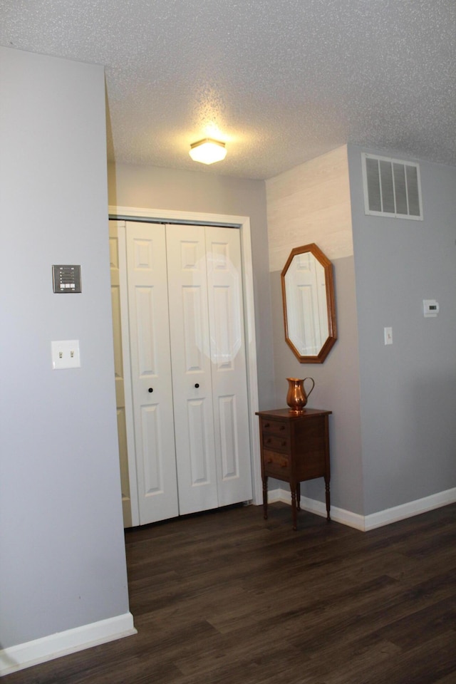3184 Windcrest Dr # 14, Grand Rapids, MI 49525 - hallway with a textured ceiling, baseboards, dark wood-style floors, and visible vents