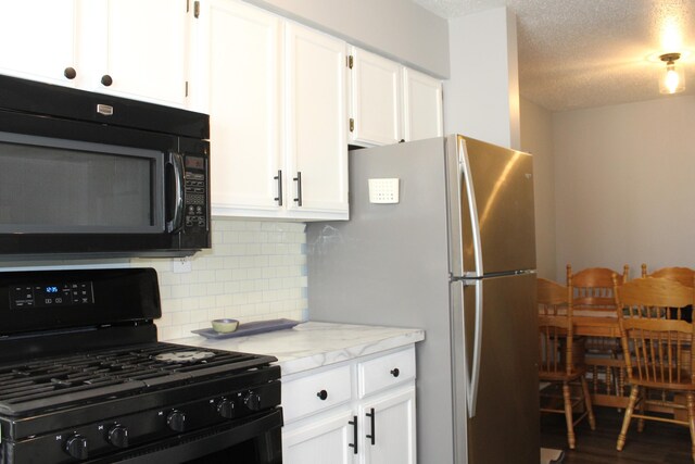 3184 Windcrest Dr # 14, Grand Rapids, MI 49525 - kitchen featuring tasteful backsplash, black appliances, white cabinetry, and a textured ceiling