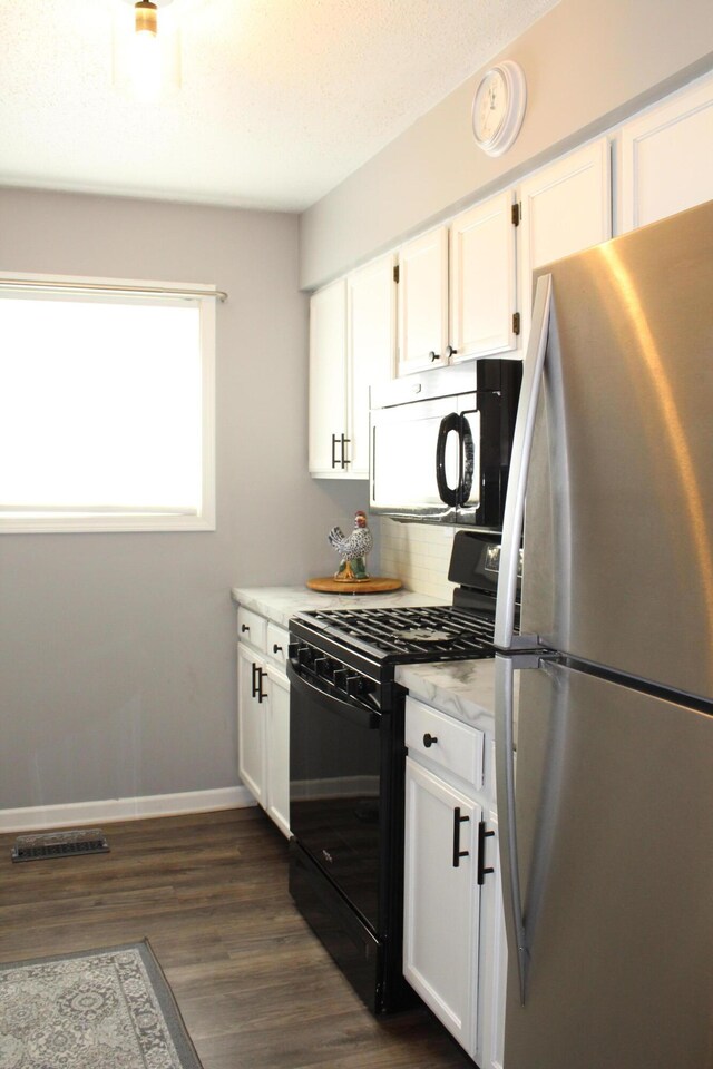 3184 Windcrest Dr # 14, Grand Rapids, MI 49525 - kitchen featuring white cabinets, freestanding refrigerator, black gas range, and dark wood-style floors