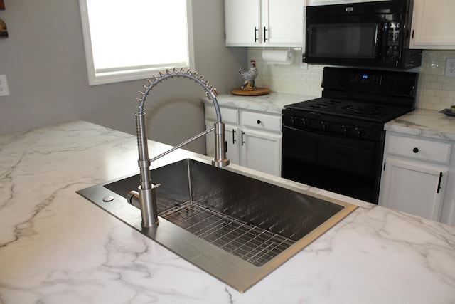3184 Windcrest Dr # 14, Grand Rapids, MI 49525 - kitchen featuring tasteful backsplash, white cabinets, a sink, black appliances, and light stone counters