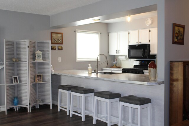 3184 Windcrest Dr # 14, Grand Rapids, MI 49525 - kitchen featuring electric range, a sink, a peninsula, and black microwave