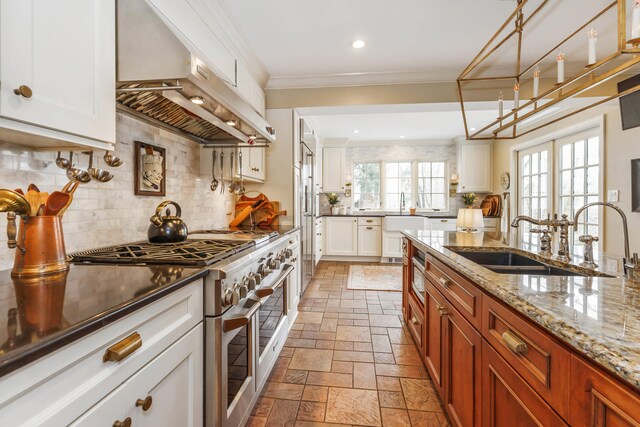 328 E 650 S, La Porte, IN 46350 - kitchen featuring ventilation hood, a sink, stone tile floors, range with two ovens, and backsplash