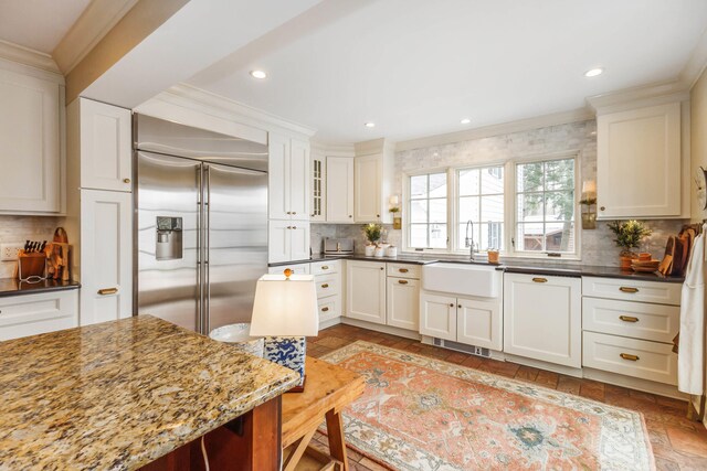 328 E 650 S, La Porte, IN 46350 - kitchen with decorative backsplash, a sink, built in refrigerator, dark stone counters, and white cabinetry