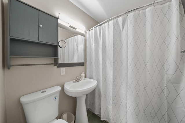bathroom with a shower with curtain, a sink, and toilet