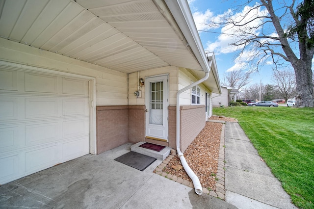 doorway to property featuring brick siding, an attached garage, and a lawn
