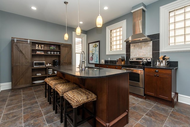 22 Jefferson Ave SE, Grand Rapids, MI 49503 - kitchen with appliances with stainless steel finishes, wall chimney exhaust hood, baseboards, a breakfast bar area, and a sink