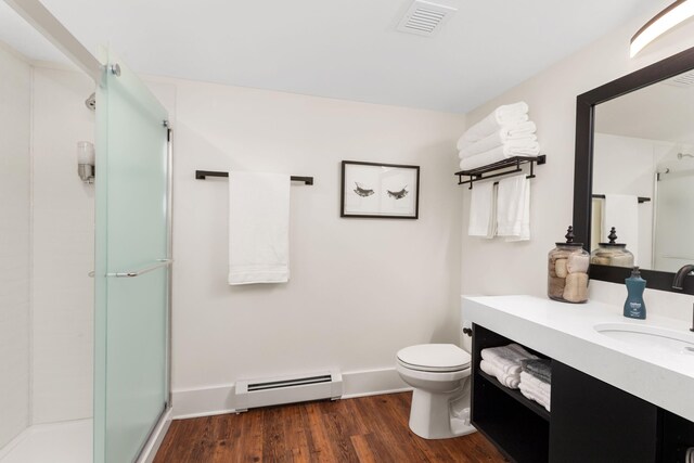 22 Jefferson Ave SE, Grand Rapids, MI 49503 - bathroom with baseboard heating, a stall shower, vanity, toilet, and wood finished floors