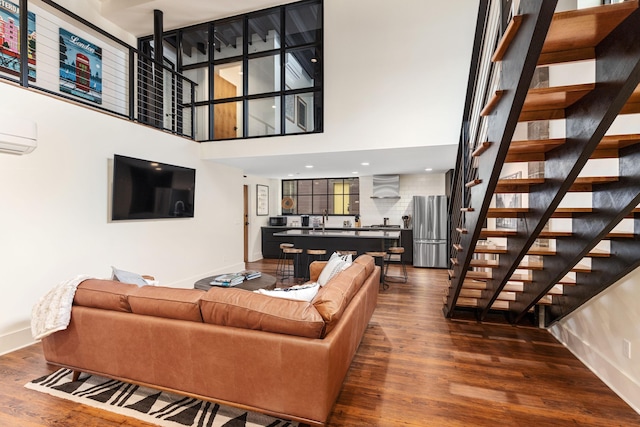 22 Jefferson Ave SE, Grand Rapids, MI 49503 - living area with a towering ceiling, baseboards, stairway, dark wood finished floors, and a wall mounted air conditioner