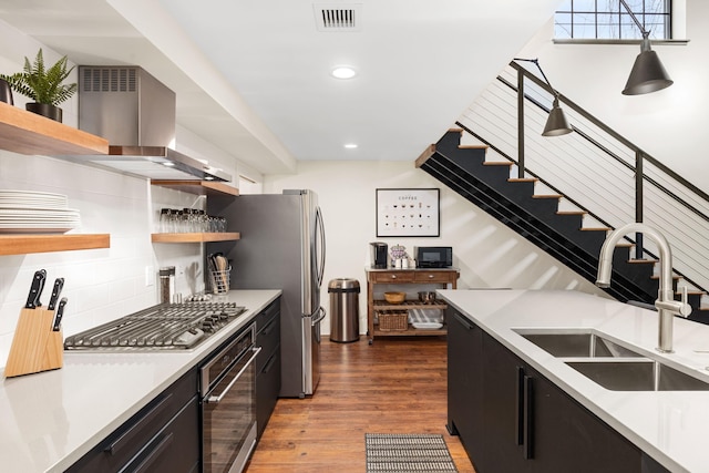 22 Jefferson Ave SE, Grand Rapids, MI 49503 - kitchen featuring open shelves, a sink, stainless steel appliances, dark cabinets, and wall chimney range hood