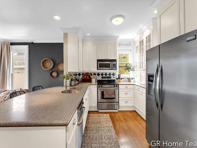 22 Jefferson Ave SE, Grand Rapids, MI 49503 - kitchen with appliances with stainless steel finishes, a sink, a peninsula, crown molding, and white cabinets