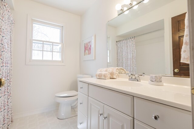 16230 Woodcrest Dr, Spring Lake, MI 49456 - bathroom with tile patterned floors, toilet, vanity, a shower with curtain, and baseboards