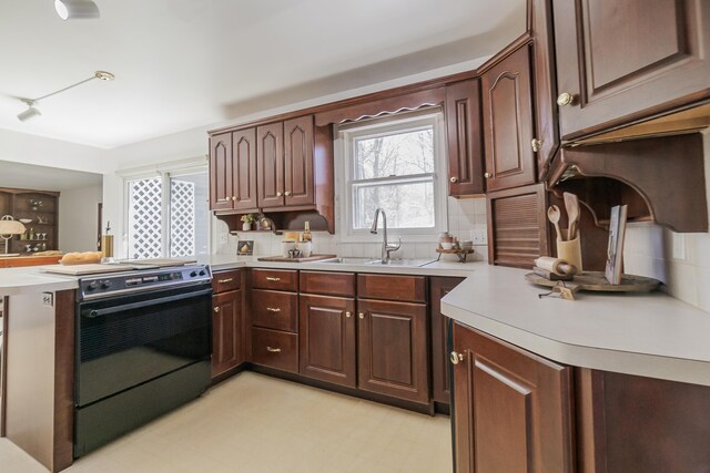 16230 Woodcrest Dr, Spring Lake, MI 49456 - kitchen with tasteful backsplash, a sink, range with electric stovetop, light countertops, and a peninsula