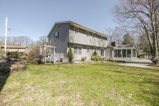 16230 Woodcrest Dr, Spring Lake, MI 49456 - rear view of property with central air condition unit, a sunroom, and a yard