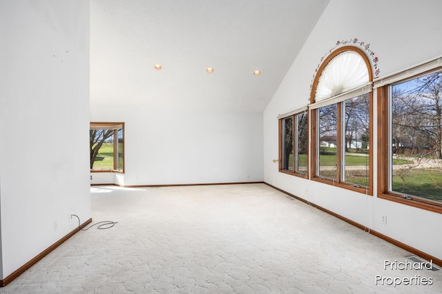 unfurnished living room featuring carpet floors, baseboards, high vaulted ceiling, and recessed lighting
