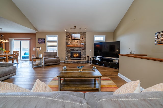 living area with baseboards, high vaulted ceiling, a fireplace, and wood-type flooring