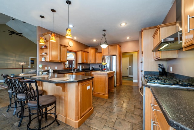 kitchen featuring pendant lighting, stainless steel appliances, under cabinet range hood, a center island, and a peninsula