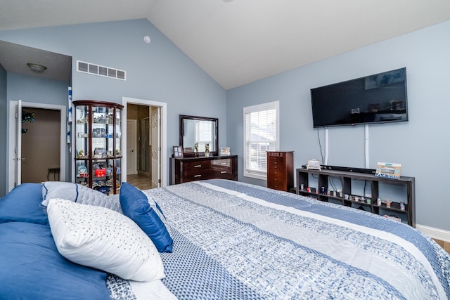 bedroom featuring visible vents, wood finished floors, and high vaulted ceiling